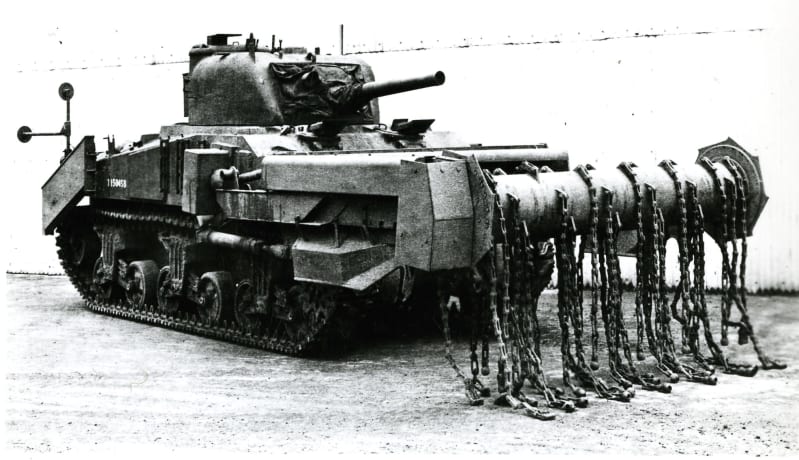 Side view of a Crab tank with arm out front with chains attached hanging down.