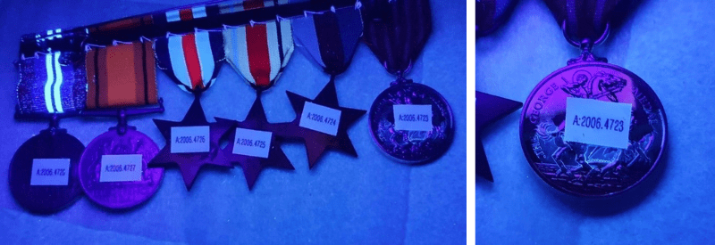 Two images of the medals with stickers under a blue UV lighting. The rightmost picture is of one medal with lighter purple lighting around the label.