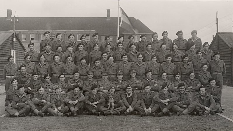 Black and white group photograph of soldiers in rows, standing and sitting.