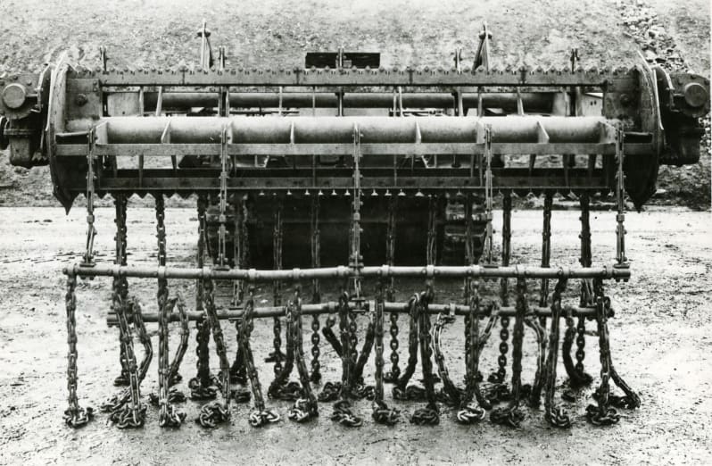 Front view of a tank with roller device at the front with chains hanging off it.