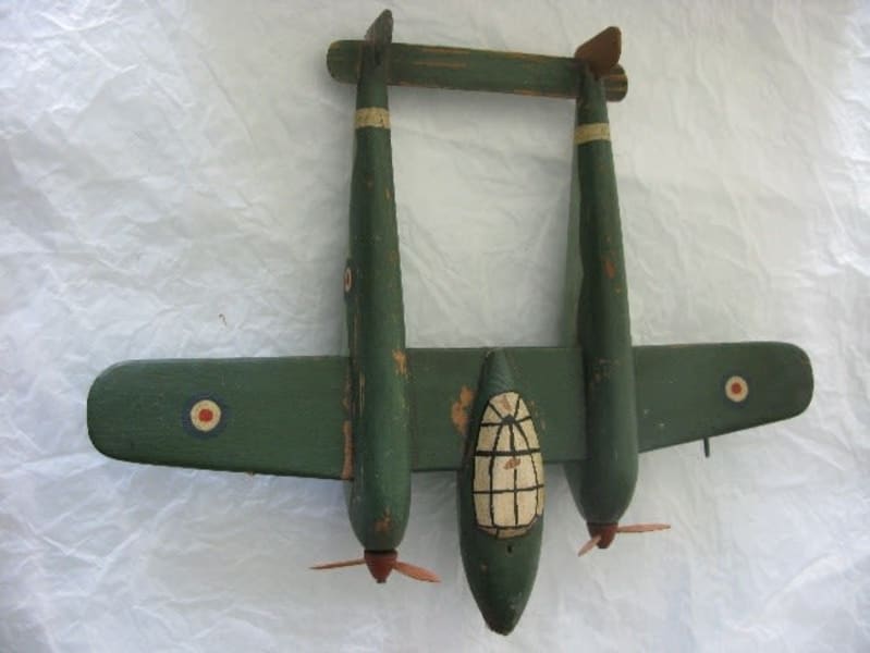 Model twin-bodied plane painted green, photographed from above. Spitfire logos on the wings.