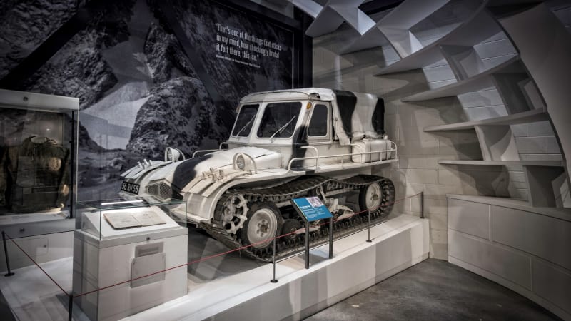 Black and white tracked vehicle on plinth inside igloo structure. Display cases surround.
