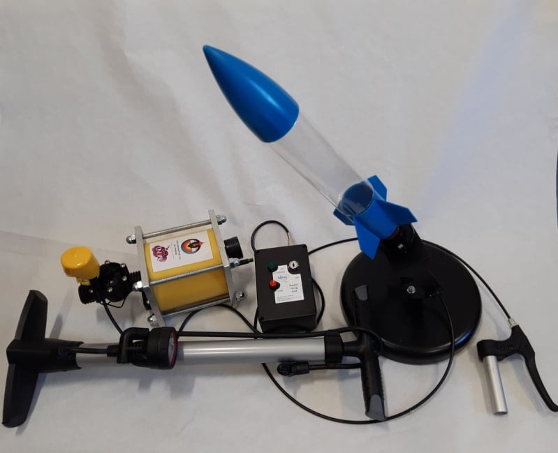 Image shows a bottle rocket attached to a pump ready to be fired. 