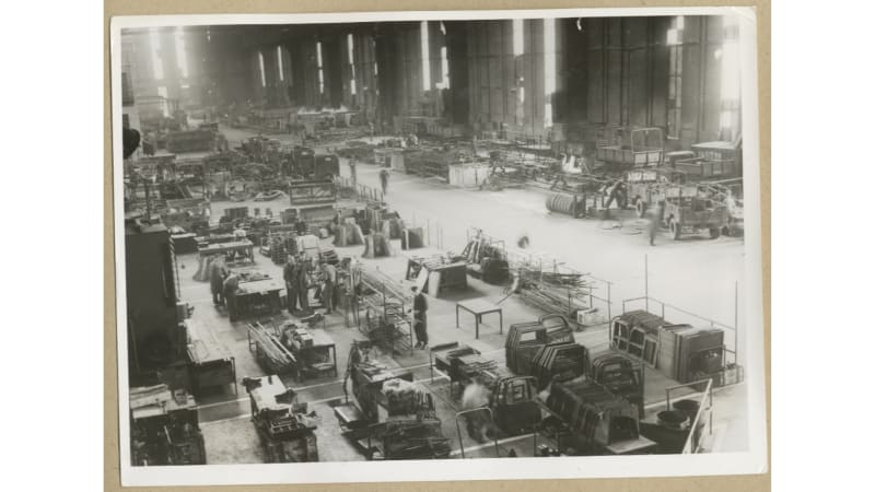 Image shows an aerial view of a workshop with external car parts all over. 