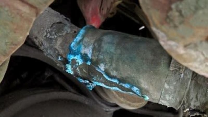 Large metal pipe with blue substance forming on the surface.