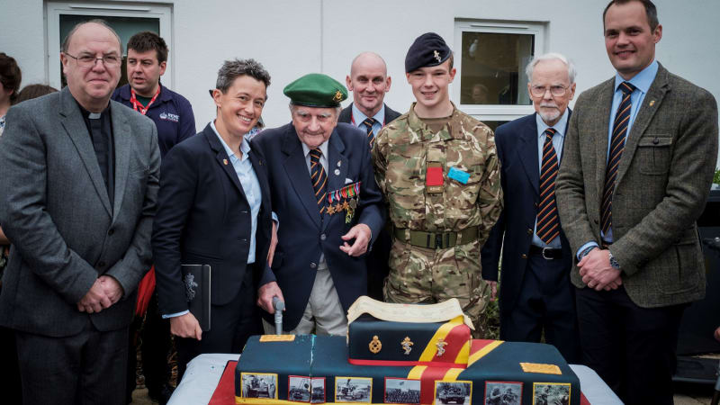 George Pratt and Craftsman Cunningham stand behind cut REME cake with other people. All look at camera. 