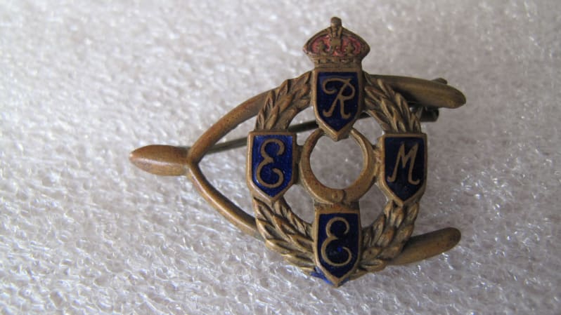 Brass coloured brooch with first pattern REME badge in the centre, sidewards clasp,