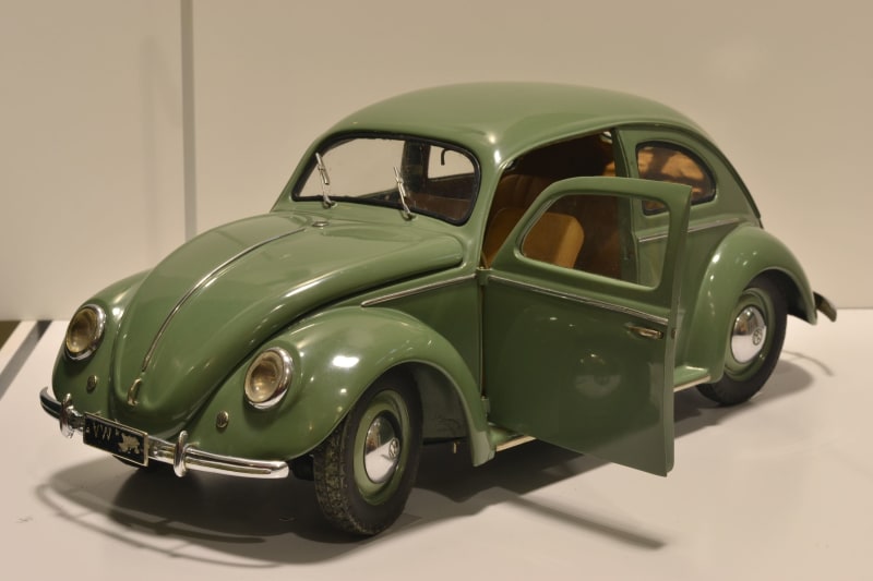 Green scale model VW Beetle with side door open.