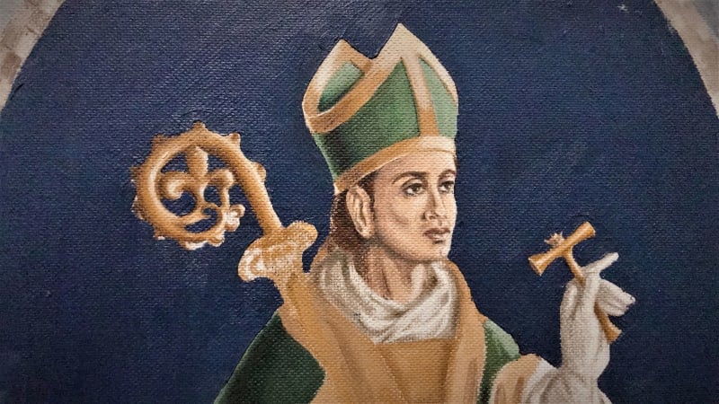A painting of the torso of St Eligius, who is dressed in a green and gold dress and hat. He holds a small, gold tool in one hand and the end of another tool can be seen behind him. 