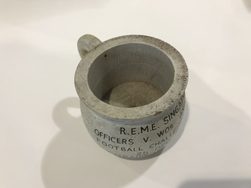 Aerial view photograph of a stone chamber pot with black text partially visible on the front.
