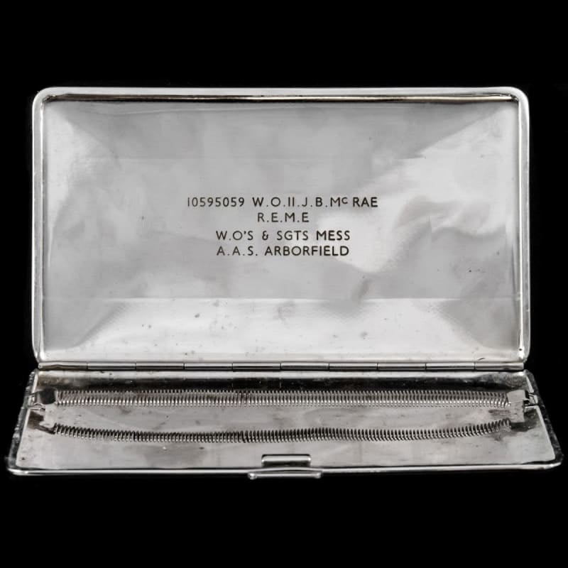 A cigarette case open, white satin lining in lid, springs in bottom. Inscription on inner lid.